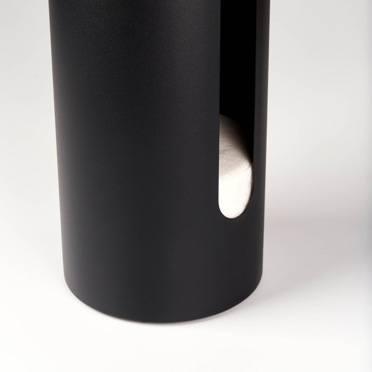 Close-up of the side cutout on the Apto Aloft Toilet Paper Stand with Storage in black steel, showing spare rolls stored inside the base