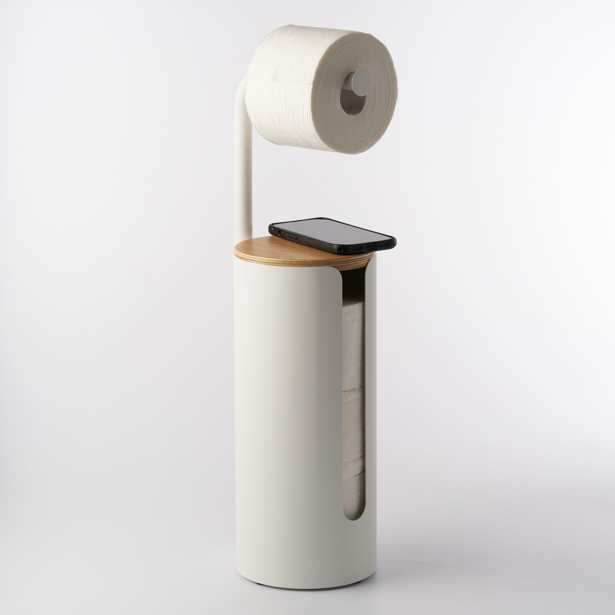 Apto Aloft Toilet Paper Stand with Storage in white with a phone resting on the wood lid and a roll on the arm, shown on a white background
