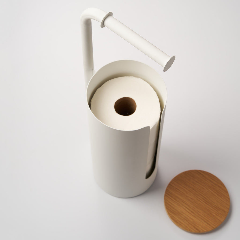 Apto Aloft Toilet Paper Stand with Storage in white with the wood lid off, showing a spare roll stored inside the steel canister