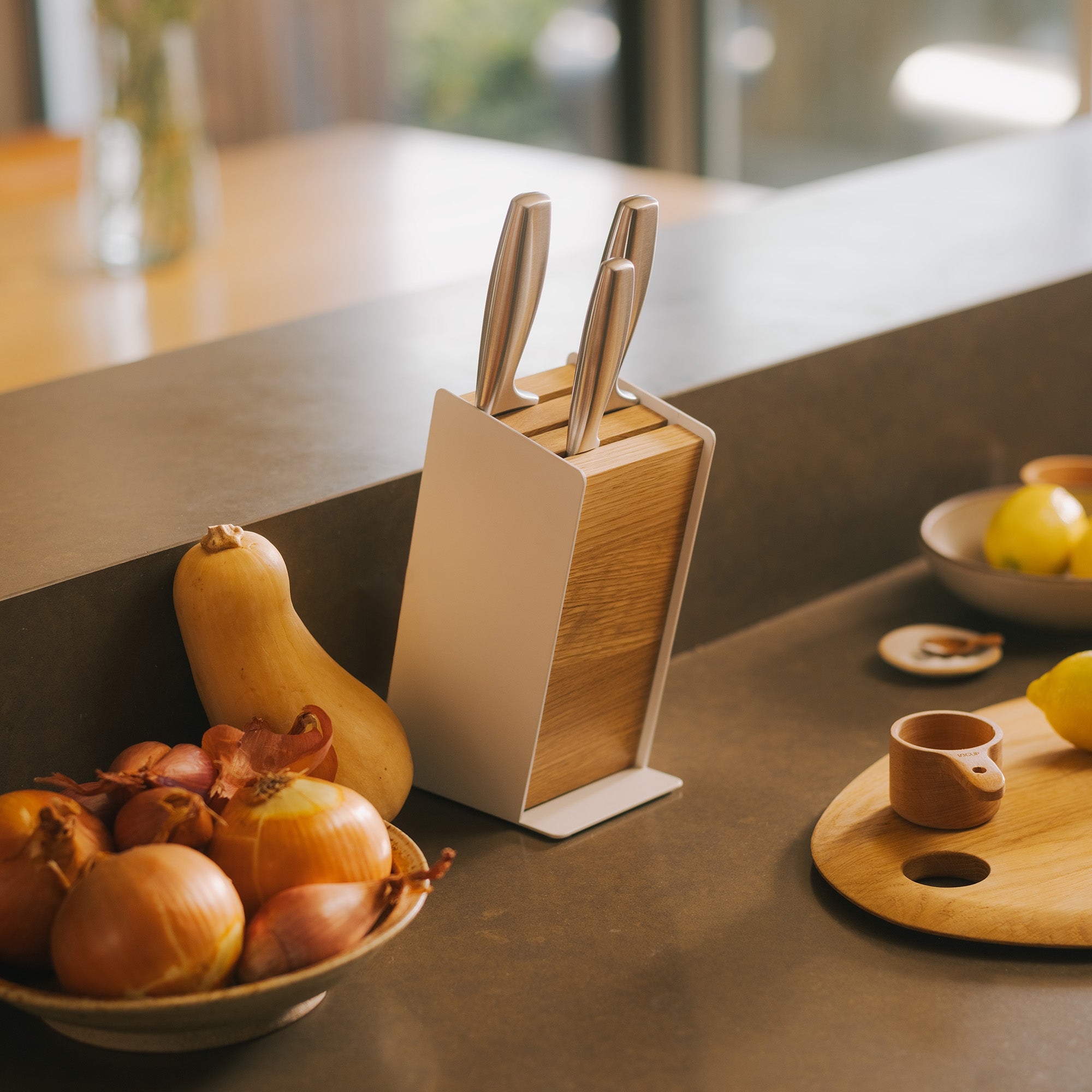 Universal knife block called the slot knife block in a modern kitchen with produce on the counter.