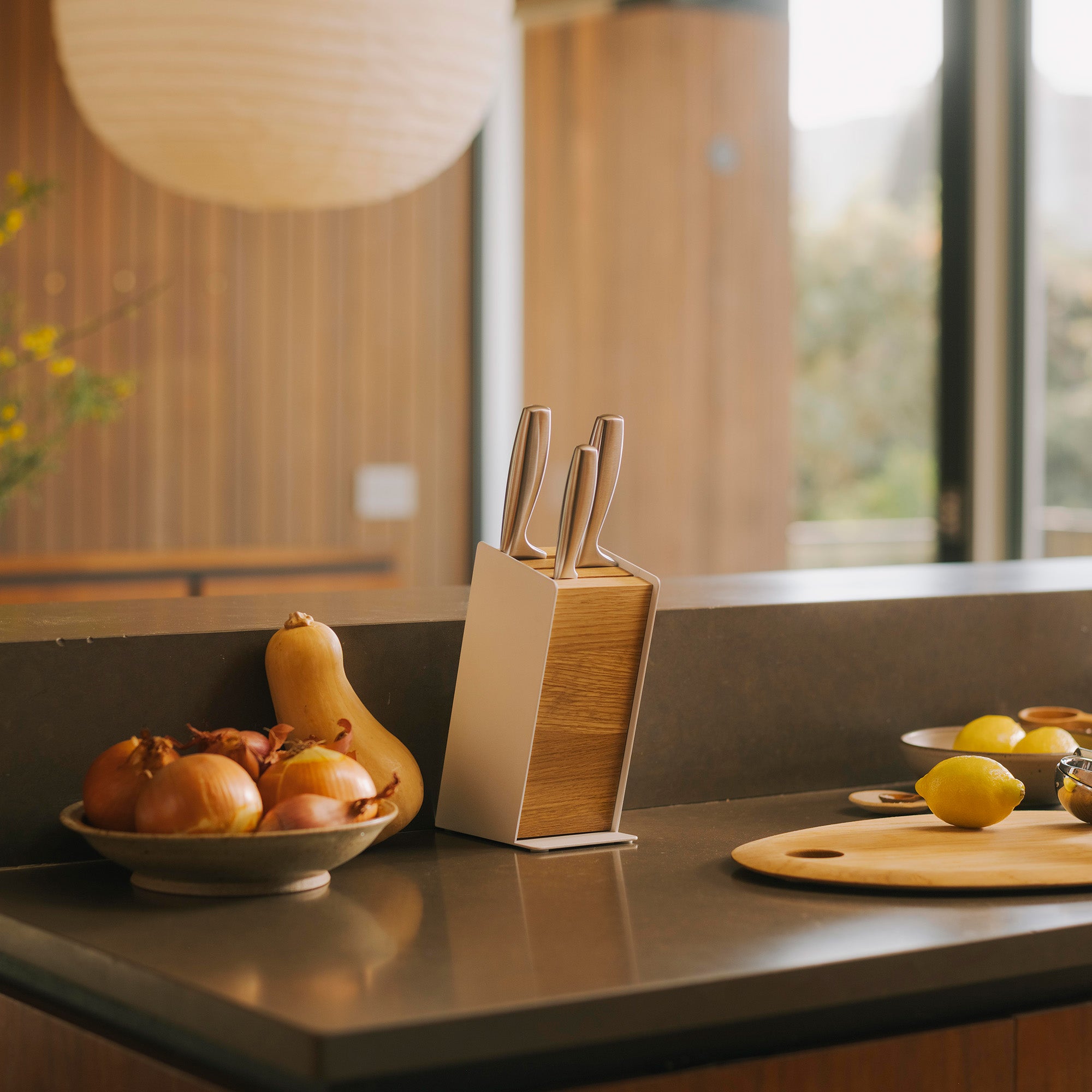 Universal knife block called the slot knife block in a modern kitchen with produce on the counter.