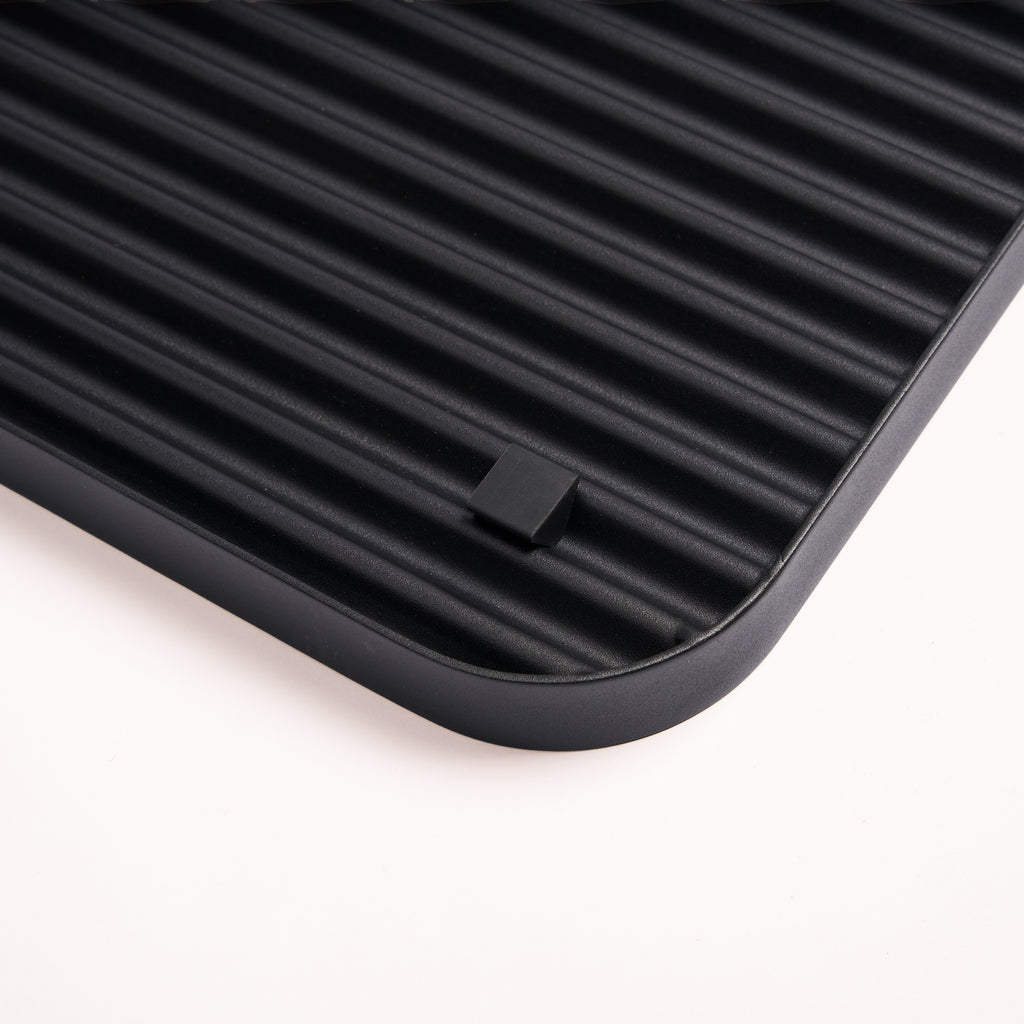 Silicone footer for stability and floor protection on the bottom of the black steel boot tray from Apto.