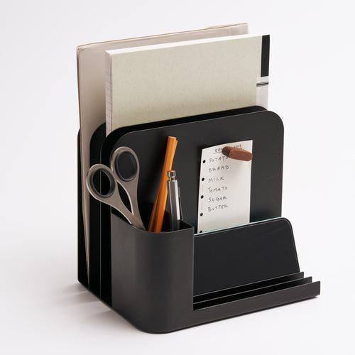 Black steel desk caddy from Apto organizing files, pens, office supplies, and post-its.