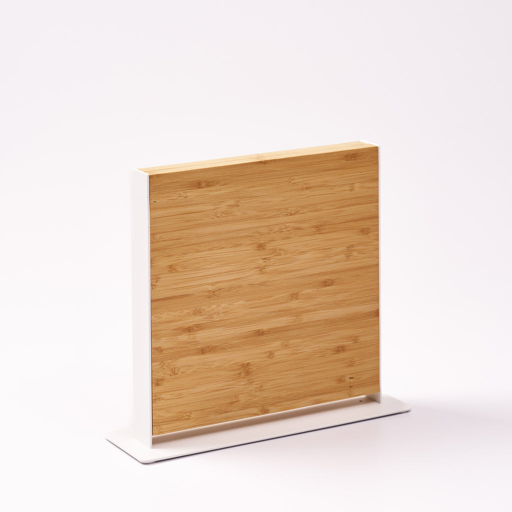 Apto Slot Knife Stand in bamboo and white steel, empty and shown at an angle on a white background to show the slim upright profile
