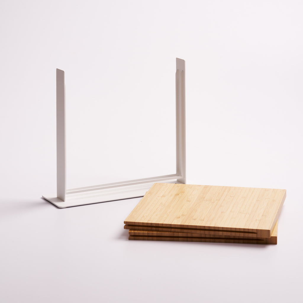 Apto Slot Knife Stand taken apart, showing the white steel frame and the stacked bamboo panels that slide in, on a white background