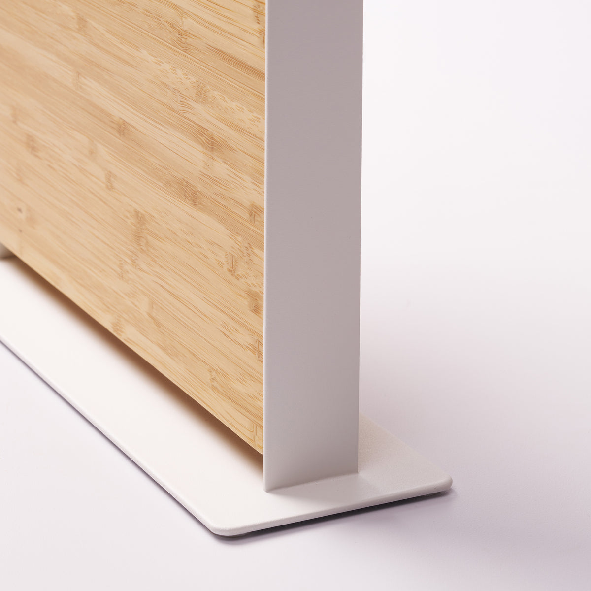 Close-up of the white steel upright and base on the Apto Slot Knife Stand, showing how the bamboo panel fits snugly into the frame