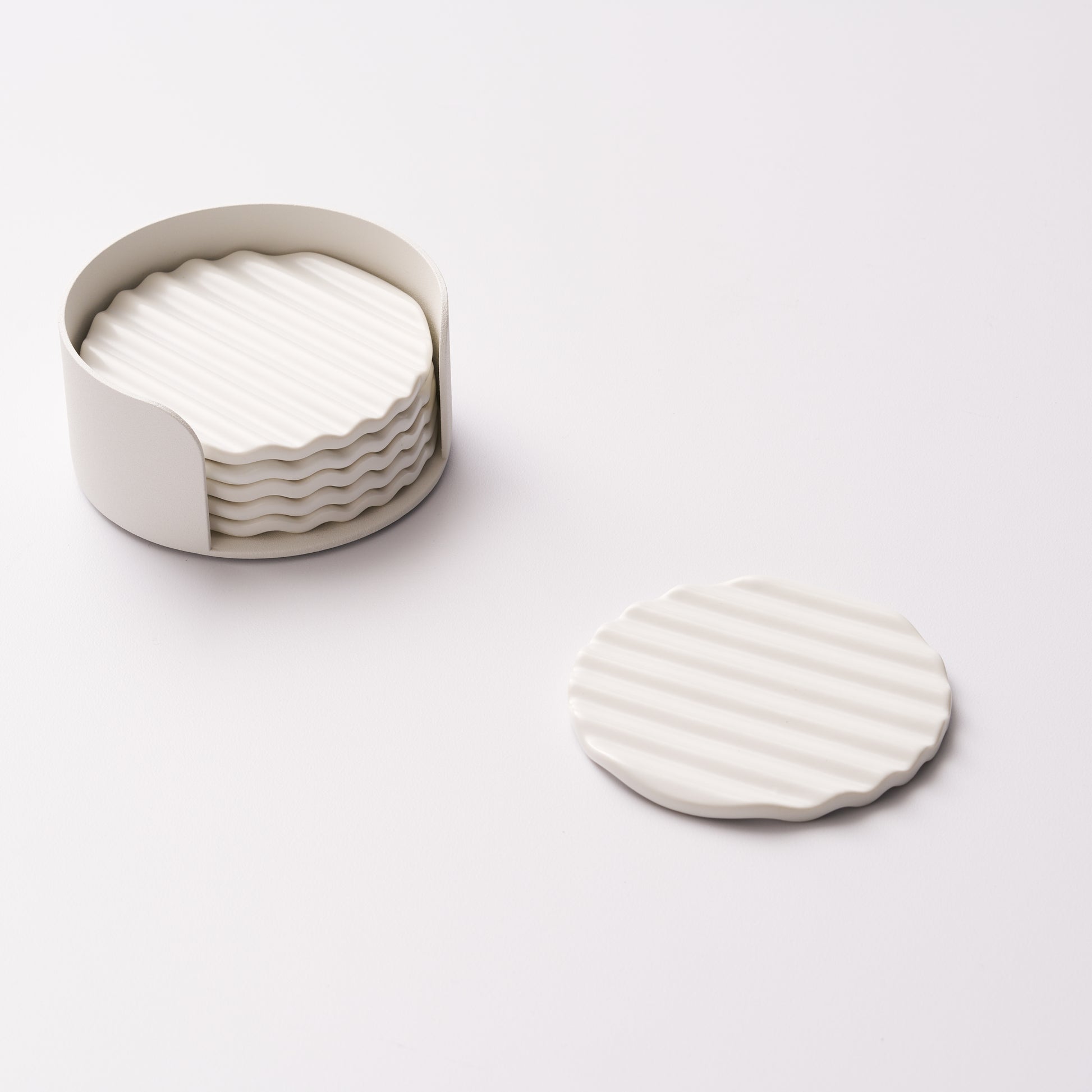 Wave ceramic coaster set in holder with one coaster displayed