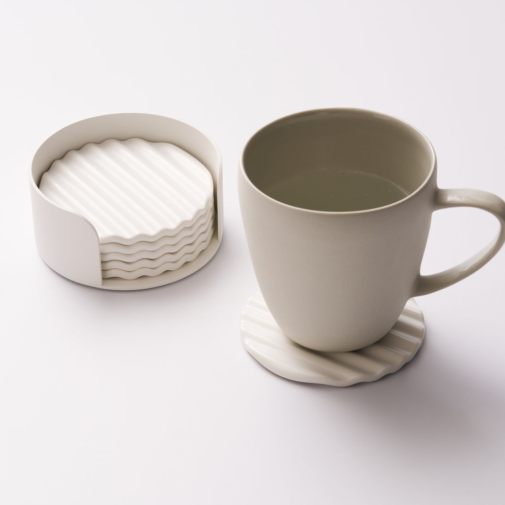 Wave ceramic coaster set in holder with one coaster displayed and holding a cup of water