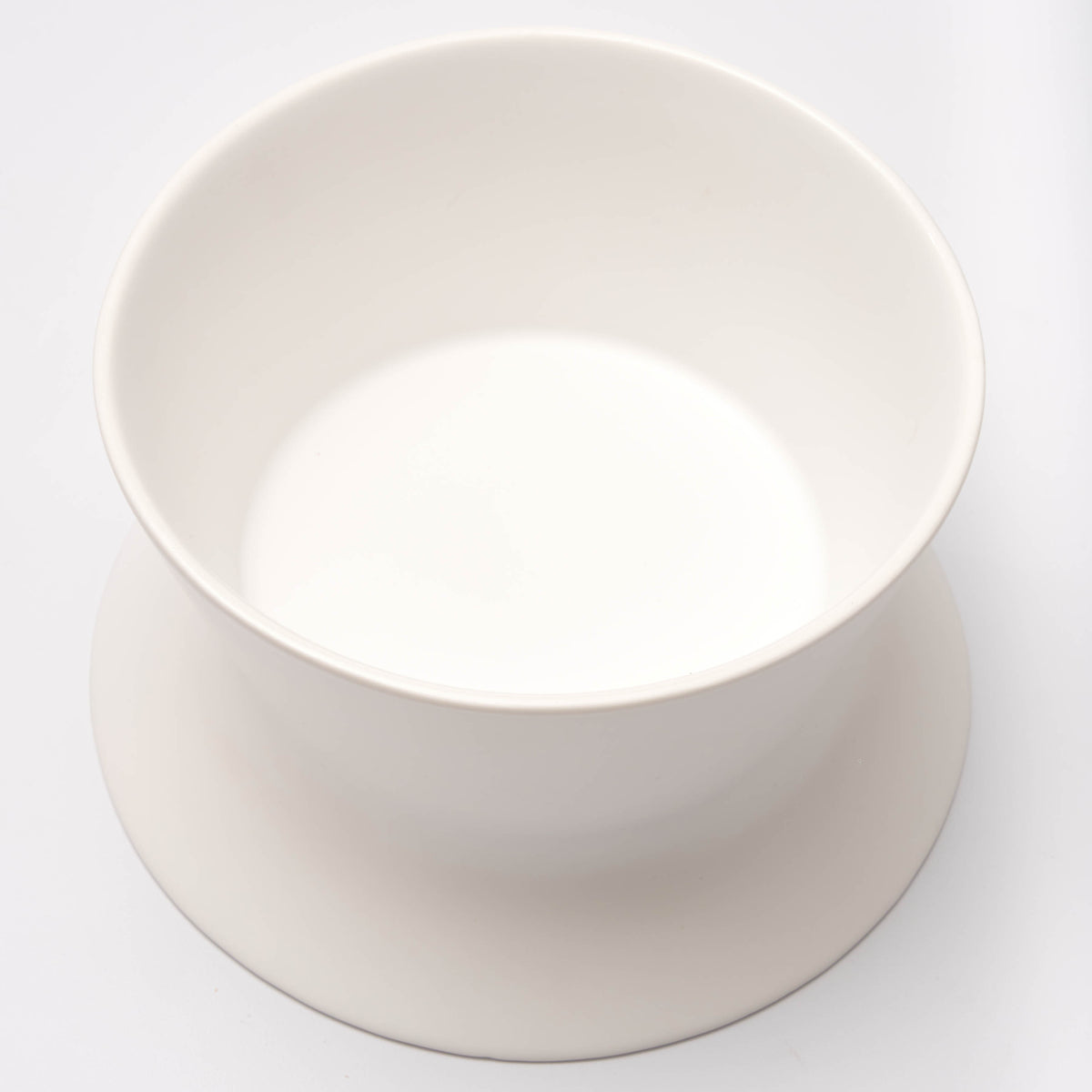 Close-up looking into the deep side of the white Apto Flip Fruit Bowl, showing the smooth matte finish and wide rim, on a plain white background