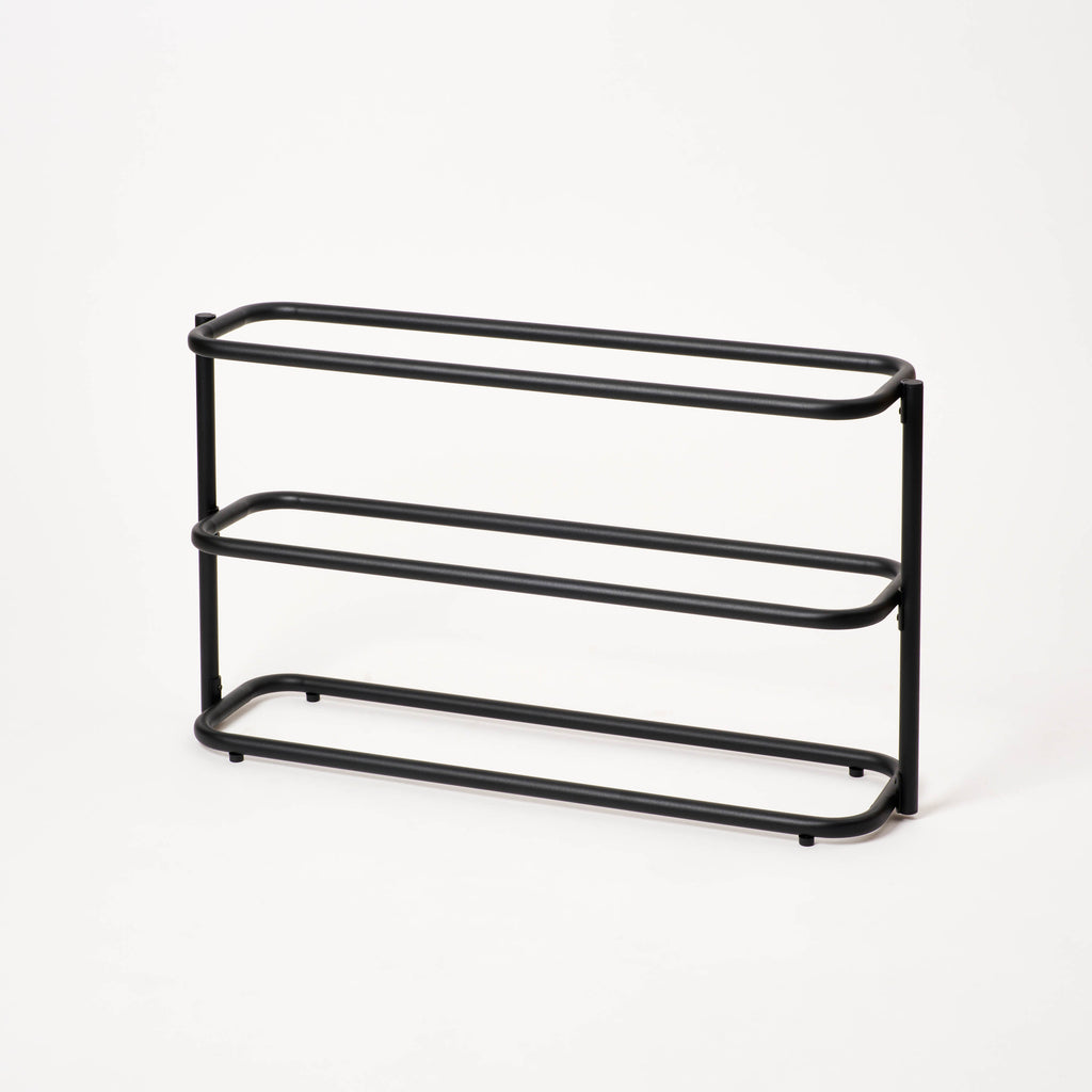 Empty Apto Obround Shoe Rack Short in black steel, shown at an angle on a plain white background to show its three rounded tiers