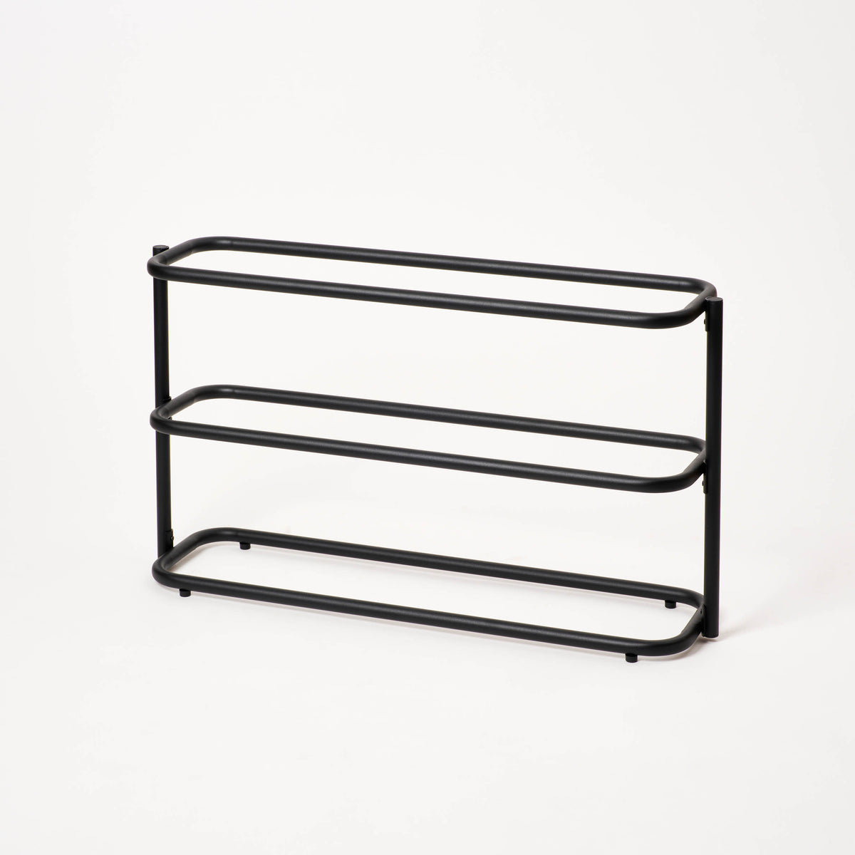 Empty Apto Obround Shoe Rack Short in black steel, shown at an angle on a plain white background to show its three rounded tiers