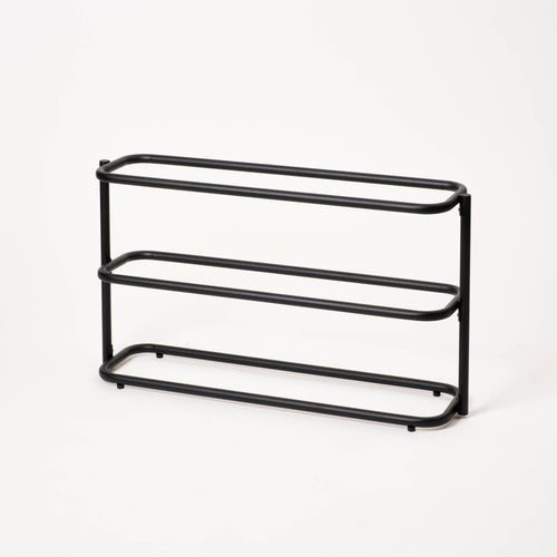 Empty Apto Obround Shoe Rack Short in black steel, shown at an angle on a plain white background to show its three rounded tiers