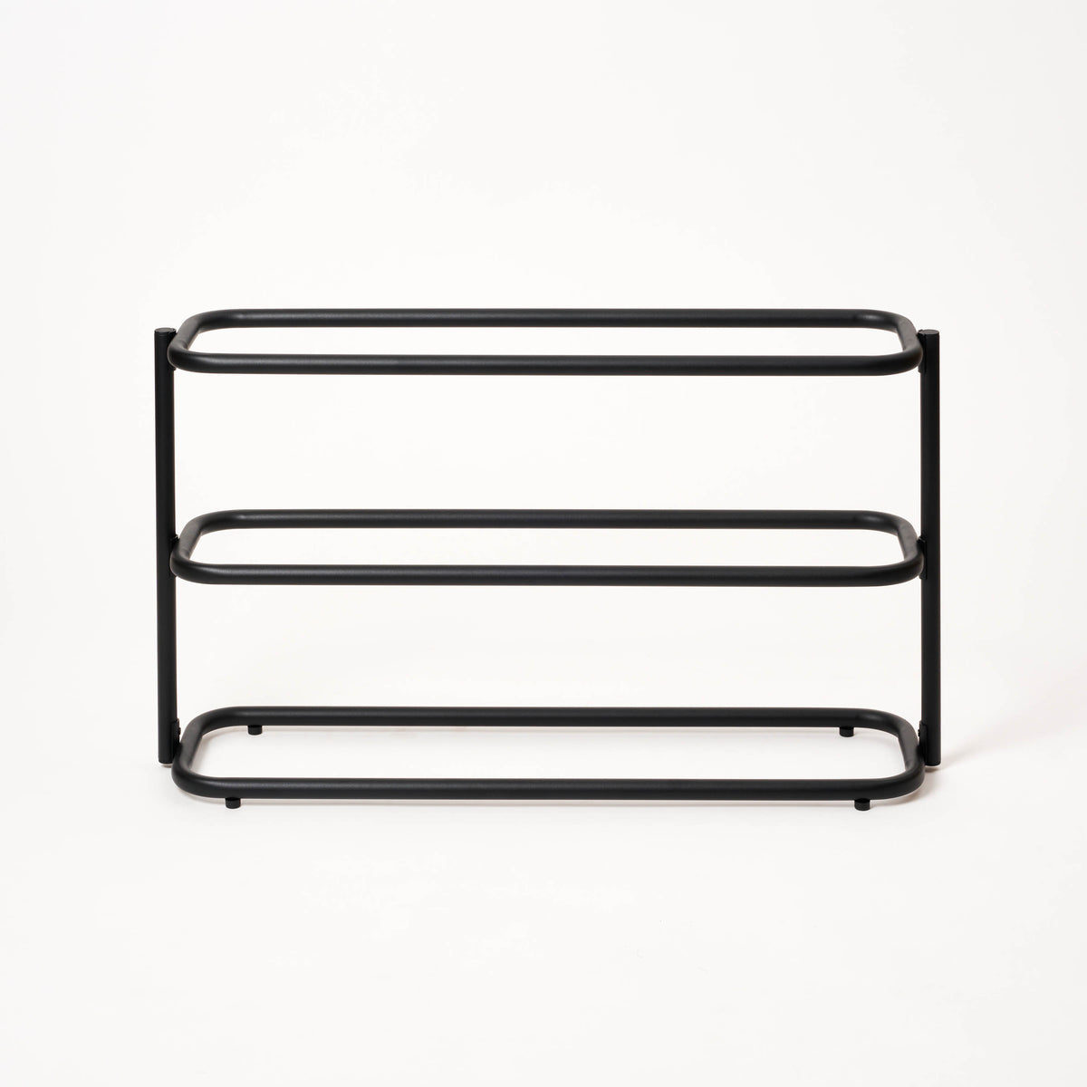 Front view of the empty Apto Obround Shoe Rack Short in black steel, showing three rounded rail tiers on a plain white background
