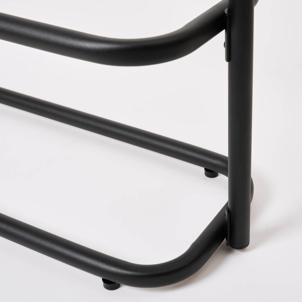 Close-up of a leg and foot pad on the Apto Obround Shoe Rack Short in black steel, showing the bottom tier on a white background
