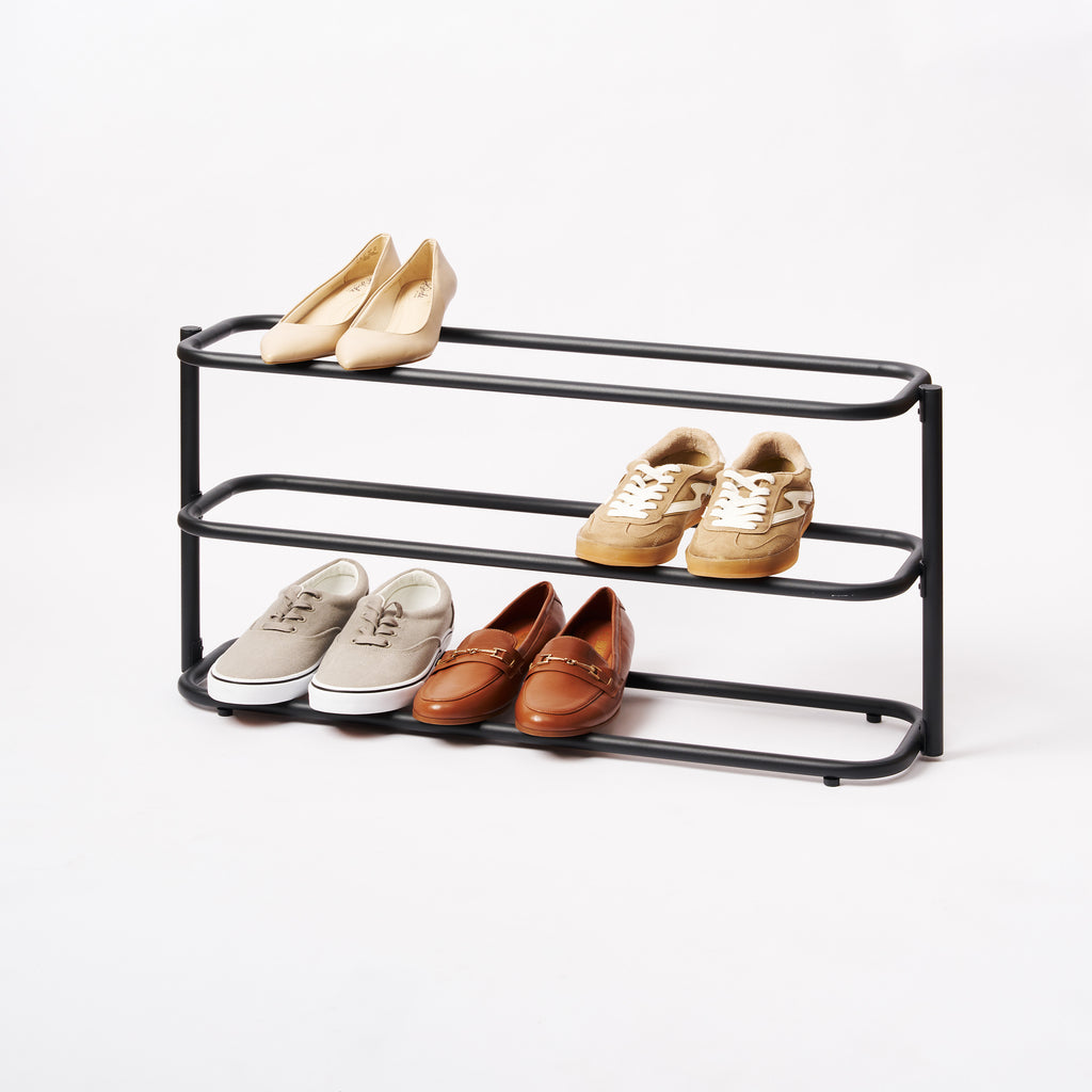 Apto Obround Shoe Rack Short in black steel holding heels, sneakers and loafers on three tiers, shown on a plain white background