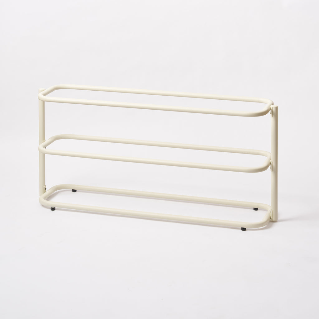 Empty Apto Obround Shoe Rack Short in ivory steel from a side angle, showing three rounded rail tiers on a plain white background