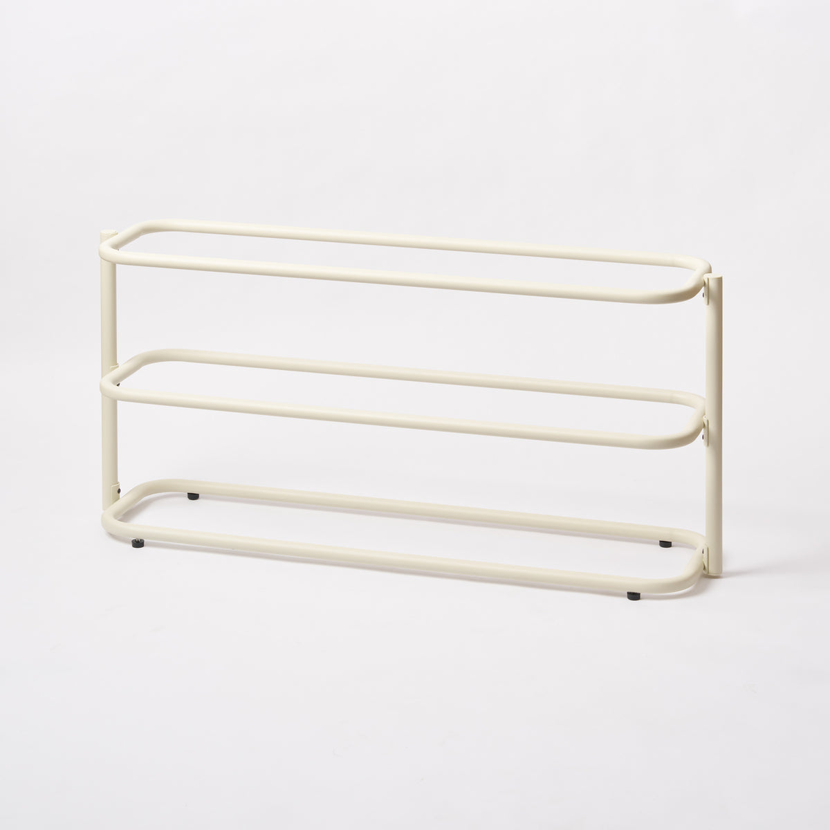 Empty Apto Obround Shoe Rack Short in ivory steel from a side angle, showing three rounded rail tiers on a plain white background