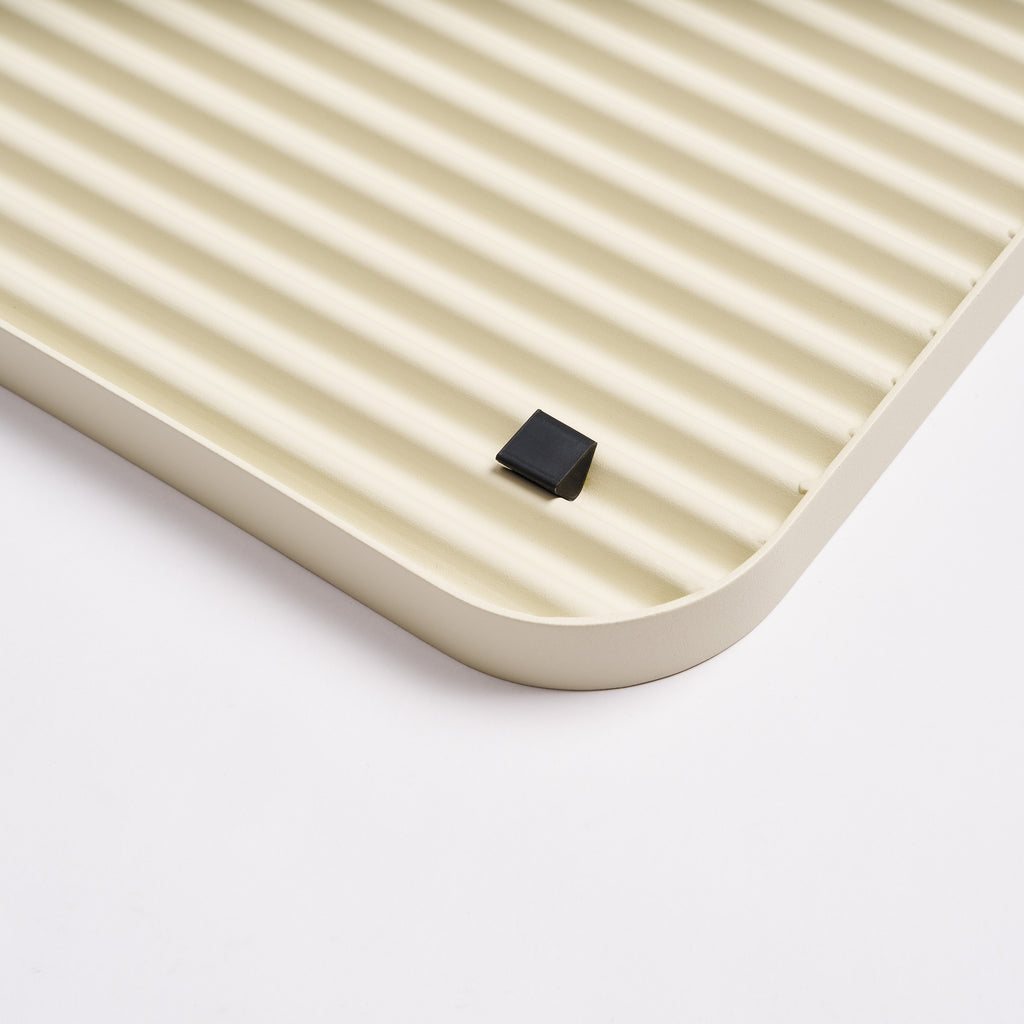 Silicone footer for stability and floor protection on the bottom of the beige steel boot tray from Apto.